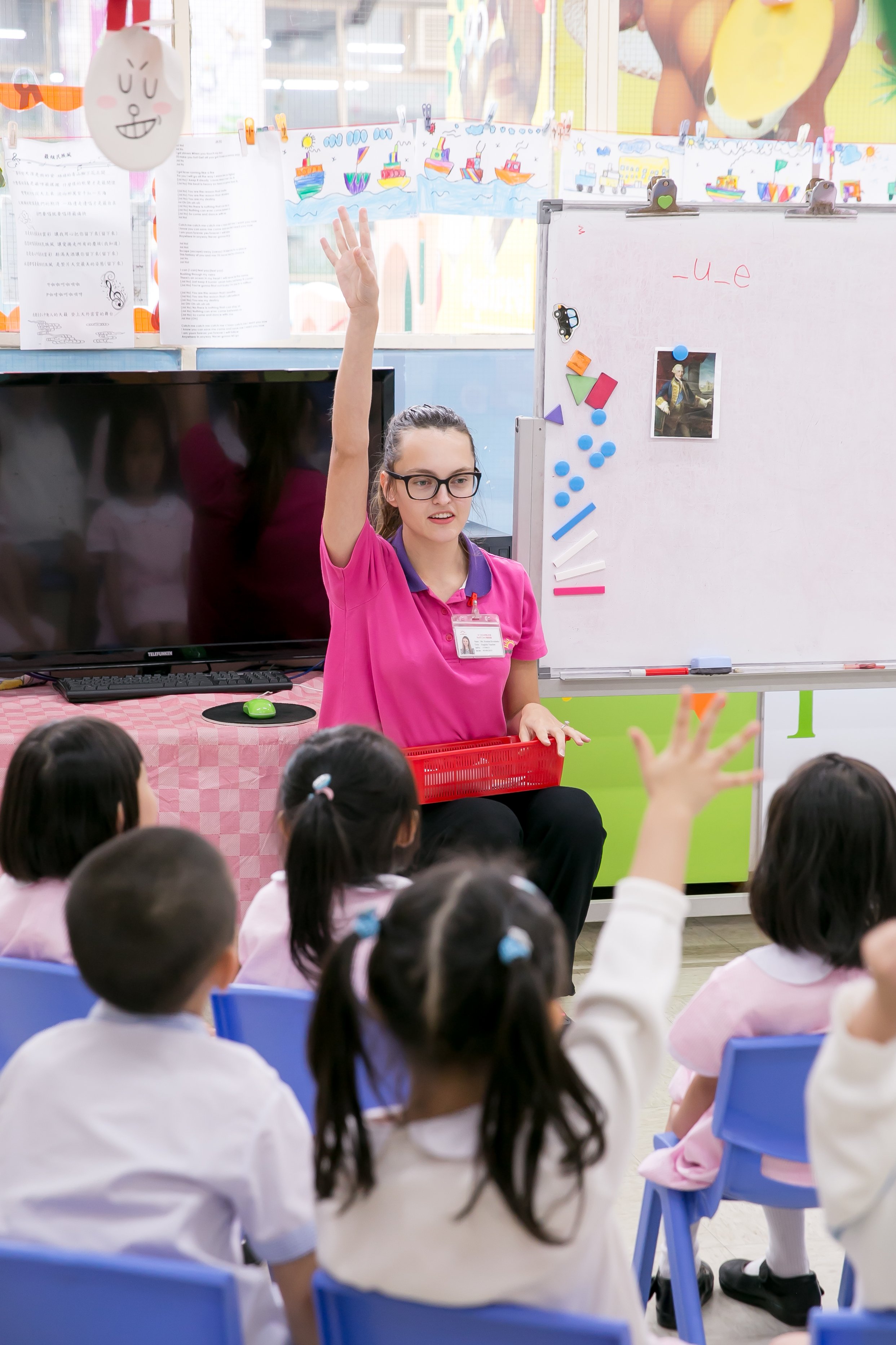 a young TEFL teacher is encouraging children to work at the lesson